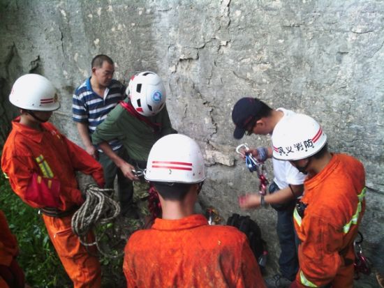 救援队员准备利用绳索攀上几乎垂直的崖壁进行救援