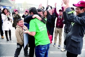 图为市民和穿绿色短袖T恤的雷闯拥抱，志愿者则在一旁鼓掌、欢呼。