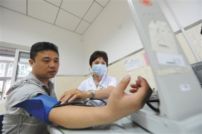 北京市大兴区一家社区卫生服务站工作人员为患者服务。资料图片
