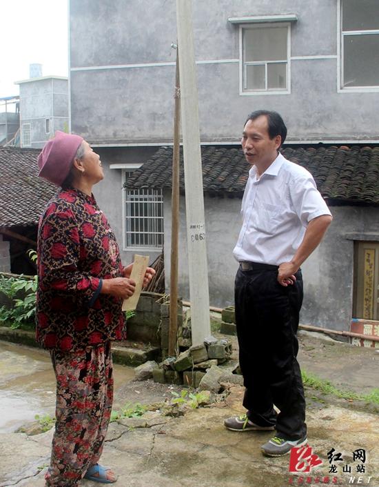 龙山县委常委、县委宣传部部长刘昌顺与贫困户交谈，了解他们的生产生活情况