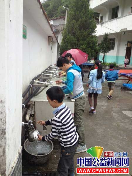图为高竹小学学生们饭后用热水清洗碗筷。西南政法大学研支团 供图