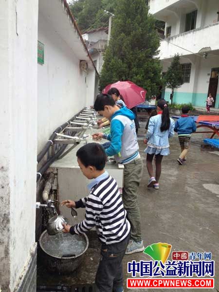 图为高竹小学学生们饭后用热水清洗碗筷。西南政法大学研支团 供图