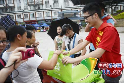 龙胜县西部计划志愿者参加禁毒宣传活动。图为志愿者向群众发放禁毒资料。高锐斌 摄