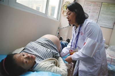 2016年7月12日，四川甘孜州妇幼保健院，一位义诊专家给当地孕妇做孕检。