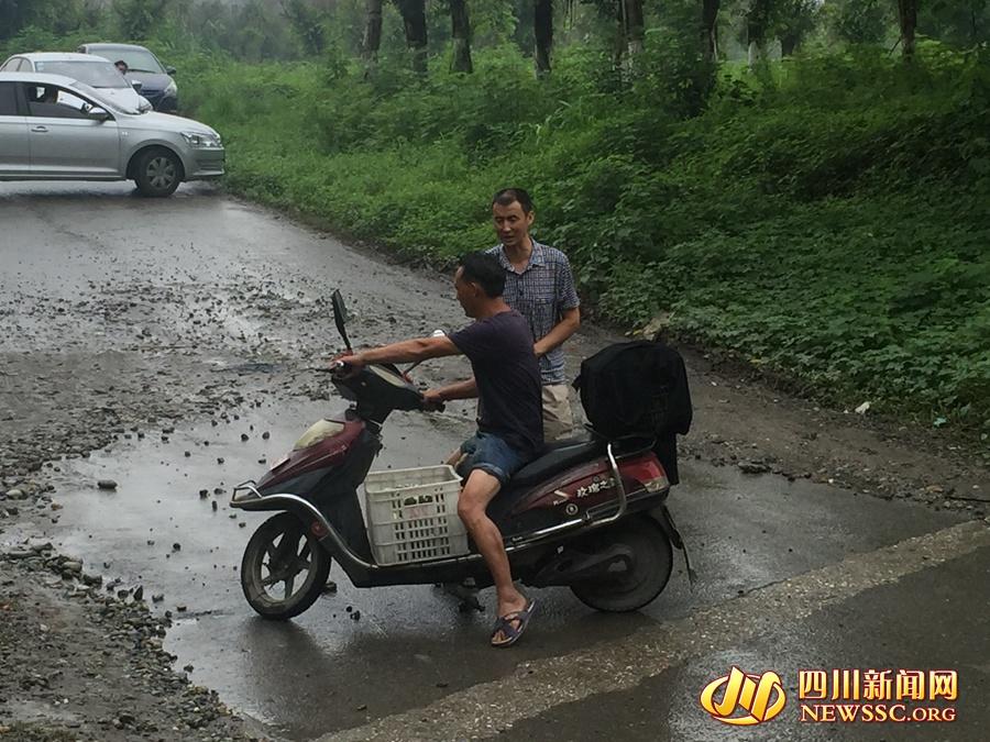 李大哥正在劝阻一位想涉水穿过隧道的电动自行车驾驶员