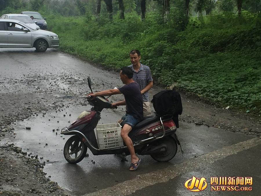 李大哥正在劝阻一位想涉水穿过隧道的电动自行车驾驶员