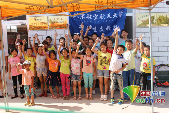 北京航空航天大学研支团成员与孩子们合影助其放飞梦想。北航研支团 供图