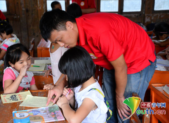 龙胜县西部计划志愿者在龙脊镇中六村小学进行为期一周的陪伴行动。图为志愿者为小朋友进行课业辅导。