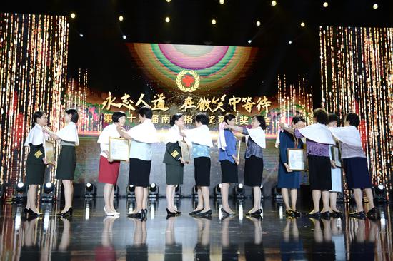 图:老一代南丁格尔奖章获得者为本届获奖者佩戴南丁格尔志愿护理服务队披肩