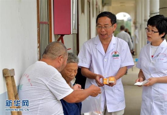28载无怨无悔在江西省皮肤病专科医院康复中心，徐根保（右二）向患者介绍服用药物的具体步骤。