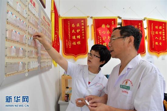 28载无怨无悔在江西省皮肤病专科医院康复中心，徐根保（右）和同事一起查看患者的就诊记录。