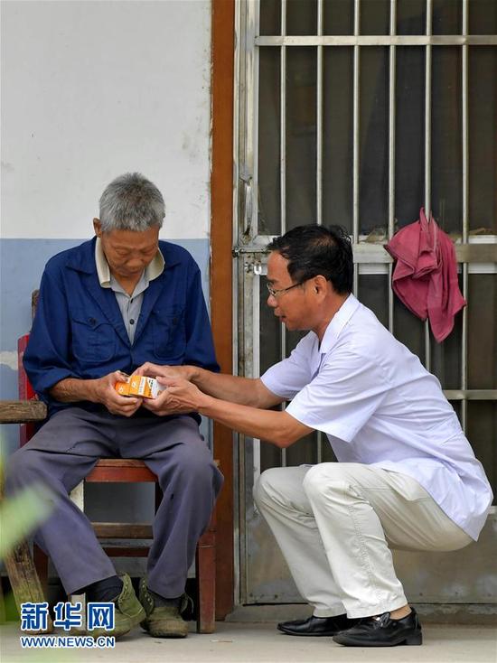 　　28载无怨无悔在江西省皮肤病专科医院康复中心，徐根保（右）在向一名患者介绍服用药物的具体步骤。