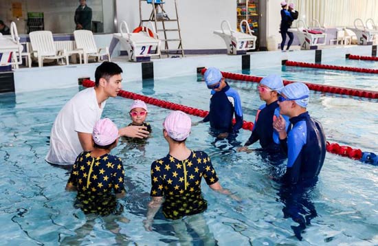 图为著名游泳运动员、“青春公益大使”宁泽涛为先心病康复患儿上游泳课。