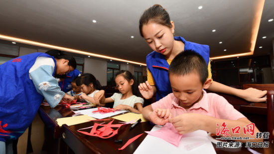 大学生志愿者在教孩子们手工折纸。见习记者 陈长宇 摄
