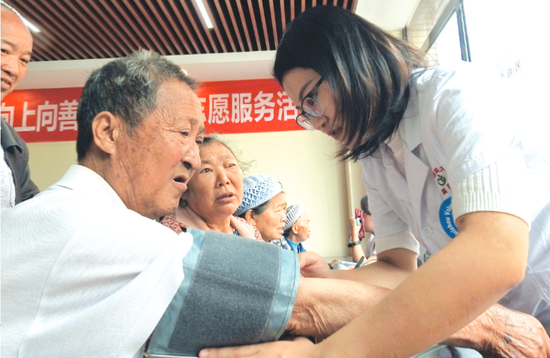 志愿者为老人测血压。