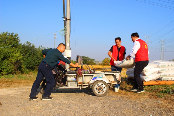 志愿者协助村民搬运肥料。焦红霞摄